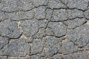 Closeup of cracked asphalt surface.